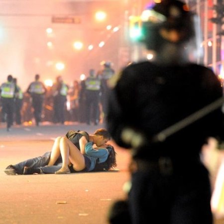 While Vancouver city was burning following the riots post their team Canucks' disgraceful defeat in Stanley Cup, a young couple - Scott Jones and his girlfriend Alex Thomas were snapped kissing amidst the commotion.