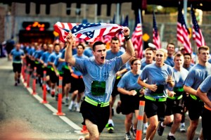 A soldier sprints while carrying an American flag during the New York City Tunnel to Towers Run to raise awareness for military causes in New York. Photo by Randall Clinton.